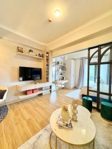 ein Wohnzimmer mit Tisch und Fernseher in der Unterkunft Twinlakes Tagaytay Vinesera Manor1 3F in Balibaguhan + 12 Fotos