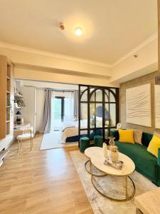 ein Wohnzimmer mit einer grünen Couch und einem Tisch in der Unterkunft Twinlakes Tagaytay Vinesera Manor1 3F in Balibaguhan