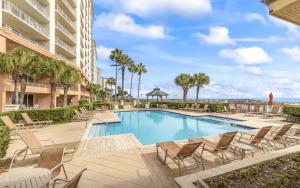 una piscina in un resort con sedie a sdraio di Beach Club 1109 D a Gulf Shores