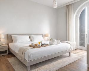 ein weißes Schlafzimmer mit einem Bett, auf dem ein Tablett mit Essen steht in der Unterkunft Vatican Pertusa Luxury Suites by Quinto Piano in Rom