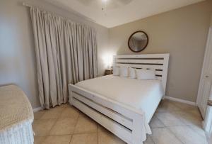 una camera da letto con un letto bianco e uno specchio di Beach Club 1109 D a Gulf Shores