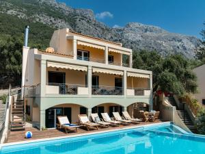 uma villa com piscina em frente a uma casa em Villa Aeolos em Barbati