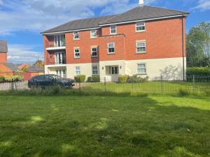 een groot bakstenen huis met een auto ervoor geparkeerd bij Double room with en-suite in Halton