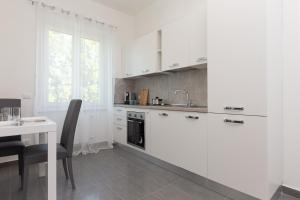 een witte keuken met een tafel en een wastafel bij ArtStay Apt Humanitas, Two Rooms, Parking in Rozzano +18 foto's