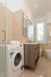 een badkamer met een wasmachine en een wastafel bij ArtStay Apt Humanitas, Two Rooms, Parking in Rozzano