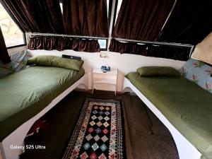 una piccola stanza con due letti e un tavolo di The Grand a Aswan