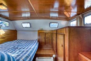 a bed in the back of a boat with windows at Bateau Gré - Sur le quai in Saint-Gilles