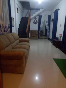 Una sala de estar con un sofá y una escalera. en Ocevia - Tangalle, en Tangalle