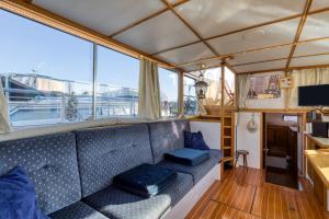 a couch in the back of a boat with blue pillows at Bateau Gré - Sur le quai in Saint-Gilles