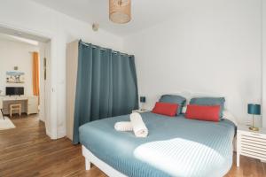 una camera con letto blu e cuscini rossi di Nid douillet en duplex proche Centre-ville & Tram a Nantes