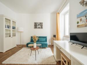 un soggiorno con un divano blu e una TV di Nid douillet en duplex proche Centre-ville & Tram a Nantes