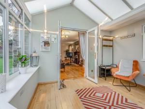 een open woonkamer met een oranje stoel en een vloerkleed bij Featherstone House in Heighington