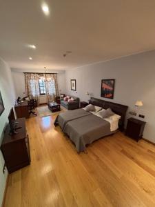 ein großes Schlafzimmer mit einem Bett und ein Wohnzimmer in der Unterkunft Tierra de Cubas in Cariñena