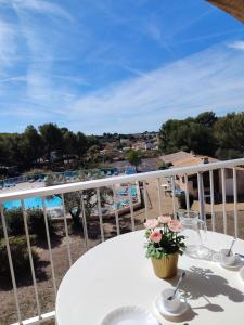 een witte tafel op een balkon met uitzicht op het strand bij Les Hauts de Balaruc in Balaruc-les-Bains