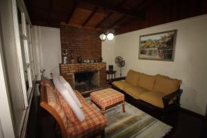 ein Wohnzimmer mit Sofa und Kamin in der Unterkunft Chácara in Mairiporã - São Paulo in Mairiporã + 17 Fotos