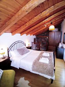a bedroom with a large bed with a wooden ceiling at Kaimak Whisper in Palaios Agios Athanasios