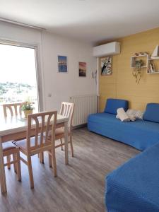 een kamer met een tafel en een bed en een tafel en stoelen bij Les Hauts de Balaruc in Balaruc-les-Bains