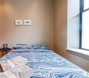 un letto blu e bianco in una stanza con finestra di Budget Comfortable Apartments a New York