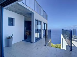 ein Haus mit Balkon mit Blick auf das Meer in der Unterkunft Villa Espigão With Pool in Fajã da Ovelha