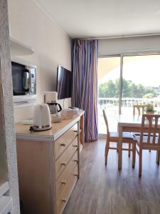 een keuken en eetkamer met een tafel en een magnetron bij Les Hauts de Balaruc in Balaruc-les-Bains +10 foto's