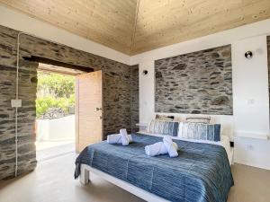 ein Schlafzimmer mit einem großen Bett mit zwei Kissen darauf in der Unterkunft Villa Espigão With Pool in Fajã da Ovelha + 31 Fotos