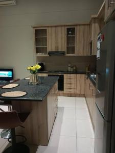 a kitchen with wooden cabinets and a stainless steel refrigerator at African Nest in Windhoek