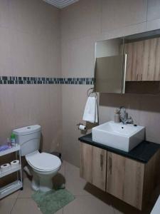 a bathroom with a white toilet and a sink at African Nest in Windhoek