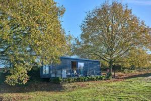 een zwart klein huisje midden tussen de bomen bij Host & Stay - Molly Mod in Marsham