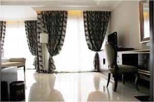 a living room with a large window and a chair at LK Royal Wing in Pattaya Central