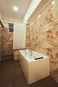 a bathroom with a sink and a marble wall at Renukamba Comforts in Chikmagalūr