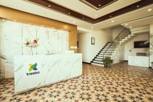 a lobby of a hotel with a counter and stairs at Renukamba Comforts in Chikmagalūr