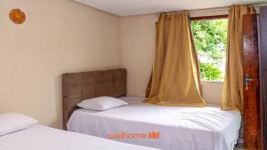 ein Schlafzimmer mit zwei Betten und einem Fenster in der Unterkunft Suite Quadrupla em Rio Grande Com Piscina in Conceição do Gato