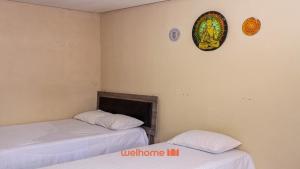 Zimmer mit 2 Betten und einer Uhr an der Wand in der Unterkunft Suite Quadrupla em Rio Grande Com Piscina in Conceição do Gato