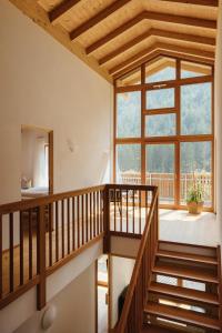 een houten trap in een huis met een groot raam bij New Opening Penthouse Zirm in Selva dei Molini