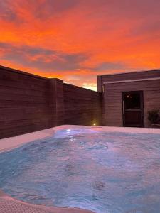 een zwembad voor een gebouw met een zonsondergang bij La vie en Roos in Maldegem