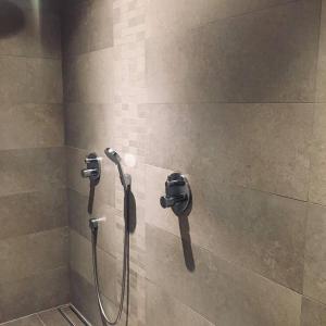 een douche met een slang aan een muur bij La vie en Roos in Maldegem +11 foto's