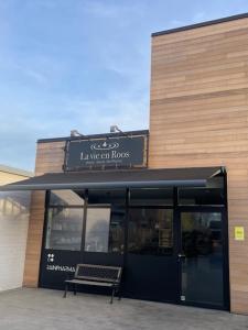 een gebouw met een bank voor een gebouw bij La vie en Roos in Maldegem