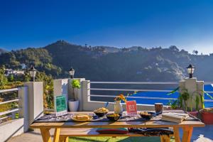 a picnic table on a balcony with a view of the ocean at PACK Mukteshwar in Mukteshwar