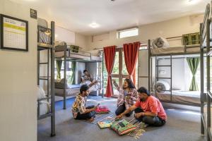 a group of people sitting on the floor in a room with bunk beds at PACK Mukteshwar in Mukteshwar