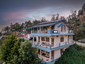 a house with blue trim on a hill at PACK Mukteshwar in Mukteshwar