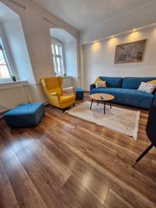 een woonkamer met een blauwe bank en een tafel bij Várker39 Apartman in Sopron