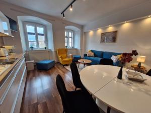 een woonkamer met een blauwe bank en een tafel bij Várker39 Apartman in Sopron