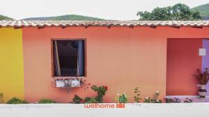 ein buntes Haus mit einem Fenster in der Unterkunft Suite em Pousada em Rio Grande com Piscina in Conceição do Gato