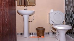 ein Badezimmer mit Toilette und Waschbecken in der Unterkunft Suite em Pousada em Rio Grande com Piscina in Conceição do Gato + 2 Fotos