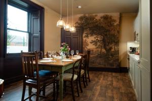 a dining room with a table with chairs and a painting at Wonderland Berwick 5-bedrooms Pet-friendly cottage with the Hot tub in Tweedmouth