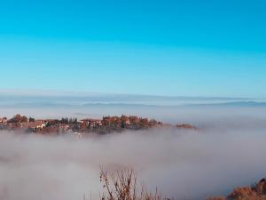 ein nebliger Blick auf eine Stadt inmitten eines Feldes in der Unterkunft Casa di Stella in Montepulciano