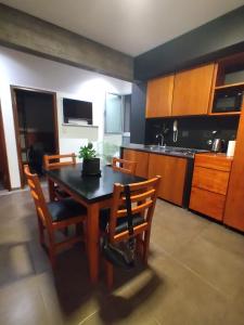 a kitchen with a wooden table and chairs and a dining room at Departamento PB en microcentro in San Salvador de Jujuy