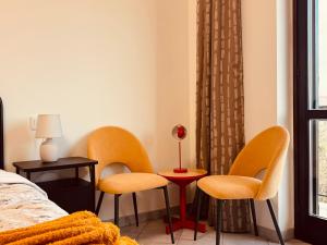 1 Schlafzimmer mit 2 Stühlen, einem Tisch und einem Bett in der Unterkunft Casa di Stella in Montepulciano