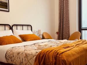 ein Schlafzimmer mit einem Bett mit orangefarbenen Kissen und einem Fenster in der Unterkunft Casa di Stella in Montepulciano