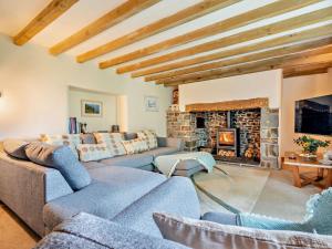 een woonkamer met banken en een open haard bij 2 Bed in Bude oc-64088 in Marhamchurch